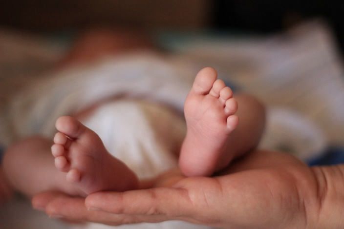A new born’s heel in the palm of a hand.