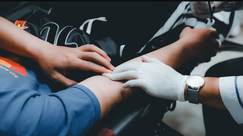 A medical practitioner collecting blood sample from a patient
