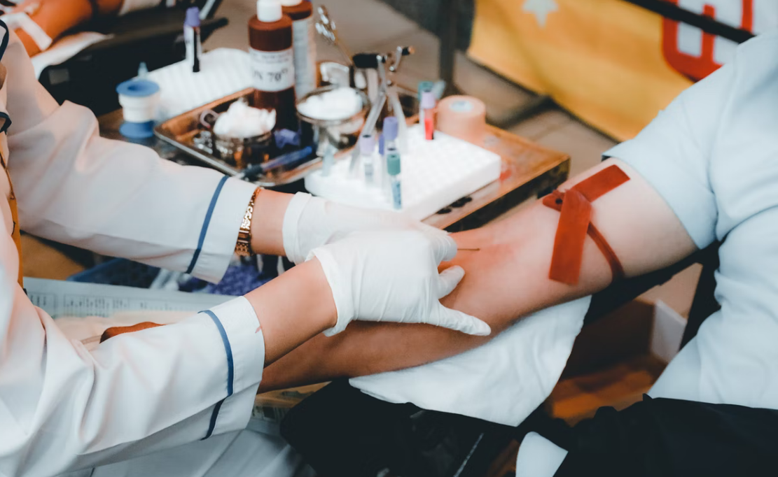 A phlebotomist performing blood draw in a lab