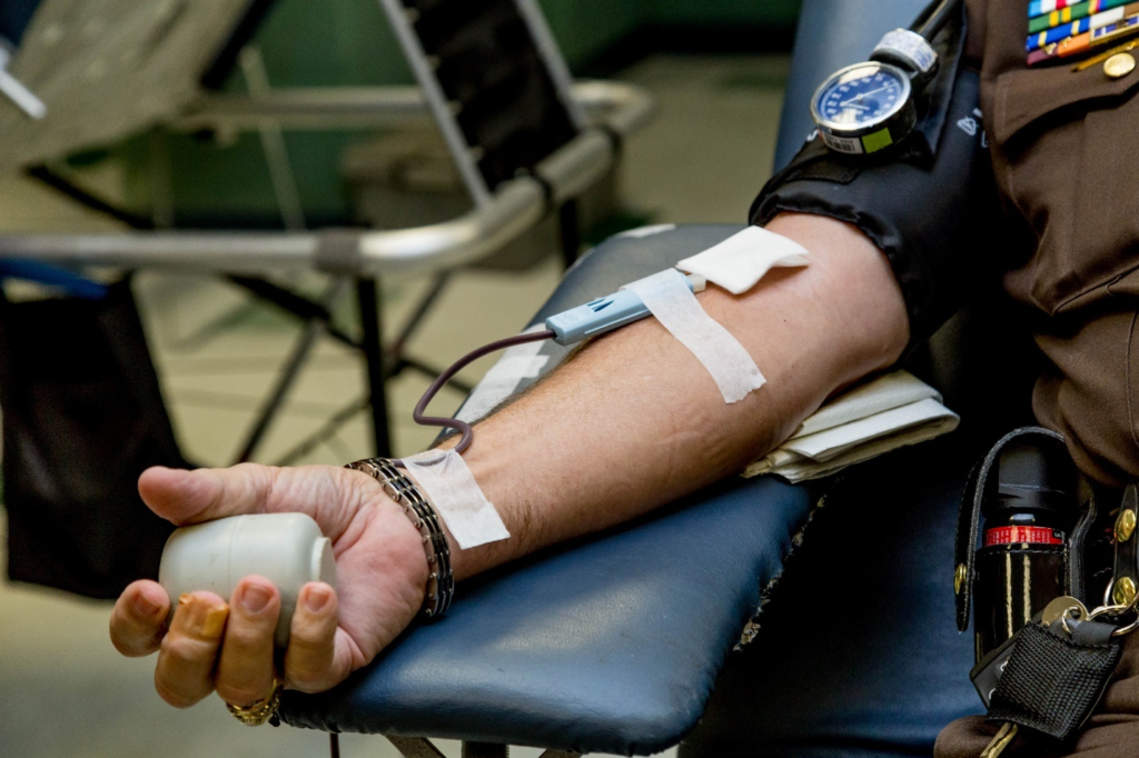 A lab phlebotomist using a syringe to draw blood 