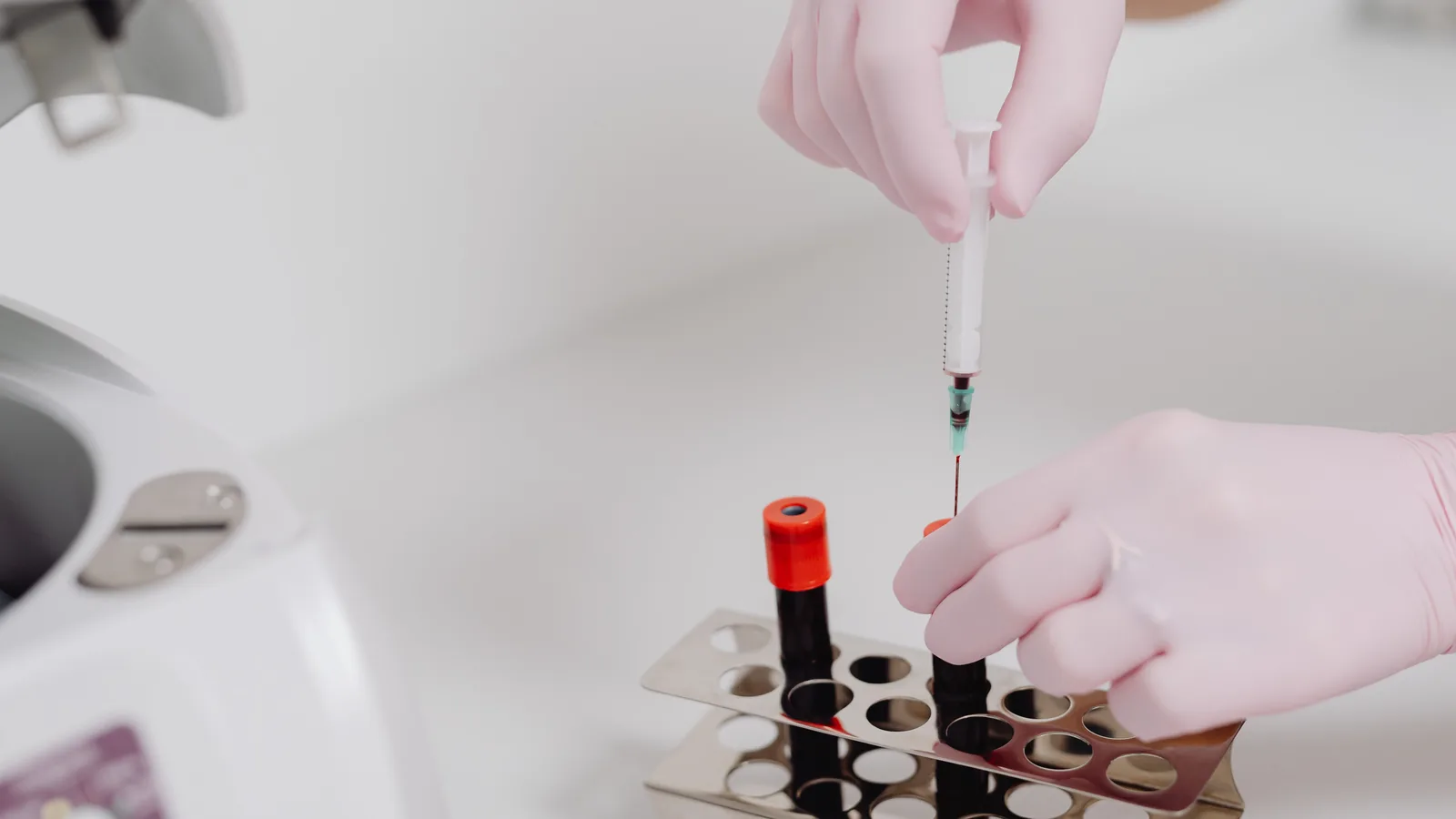 routine blood draw service in Virginia, certified phlebotomist collecting a labeled specimen tube from a blood draw rack