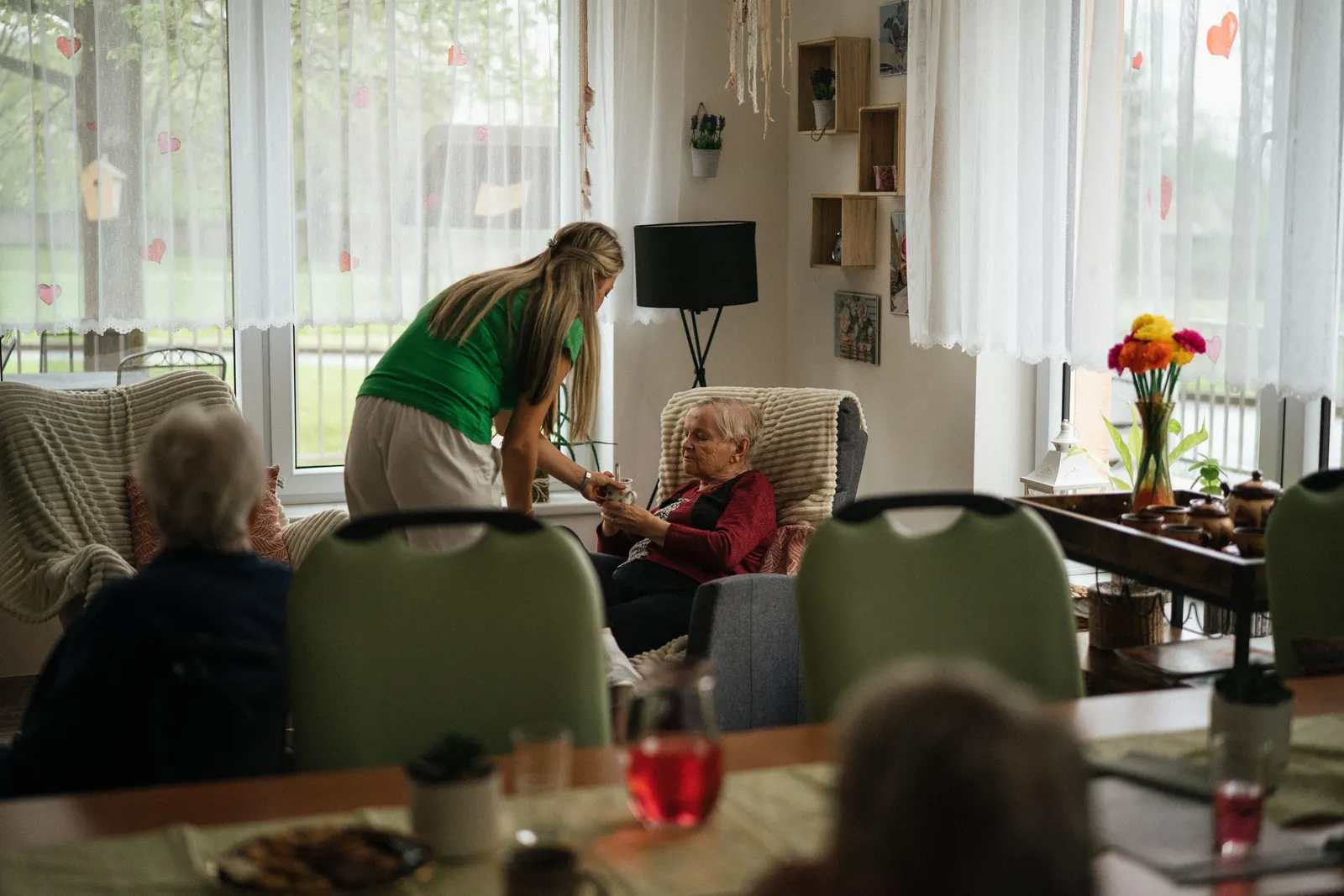 Caregiver assisting a resident in a senior living community common room